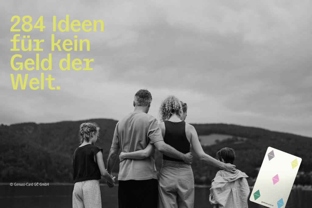 a family standing on a hill with a kite at Pension Arkadenhof in Loipersdorf bei Fürstenfeld