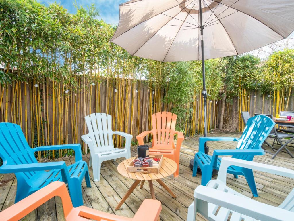 un groupe de chaises et un parasol sur une terrasse dans l'établissement Holiday Home Villa Albertine by Interhome, à Arcachon