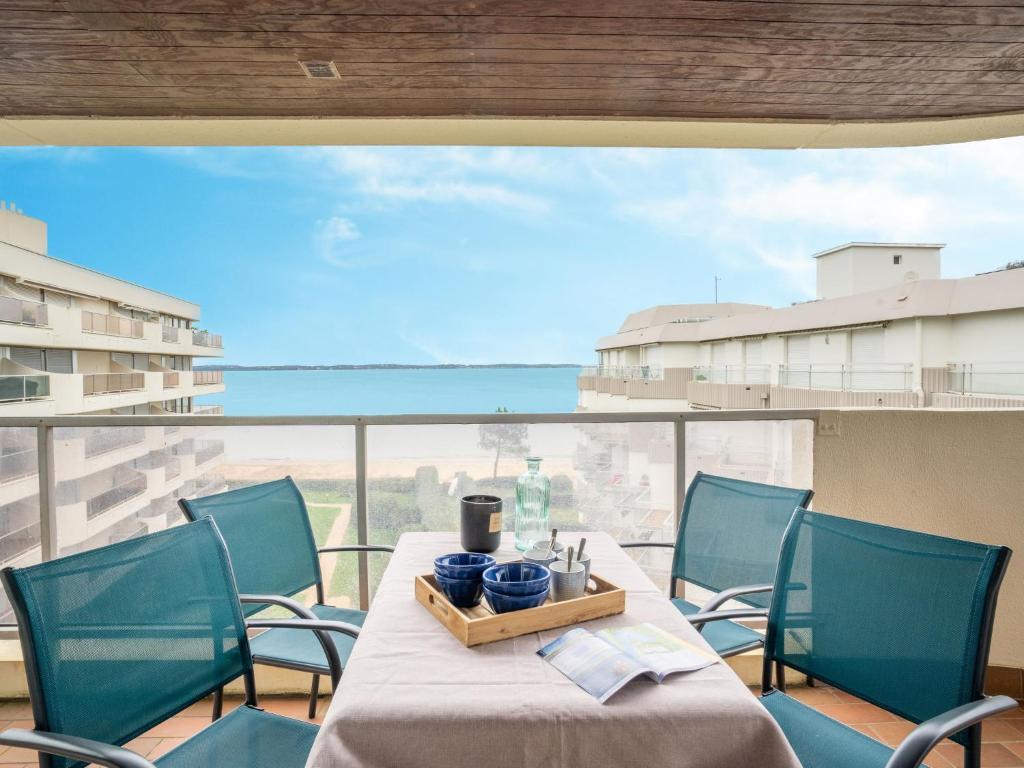 ein Tisch und Stühle auf einem Balkon mit Blick auf das Meer in der Unterkunft Apartment Aquitania-5 by Interhome in Arcachon