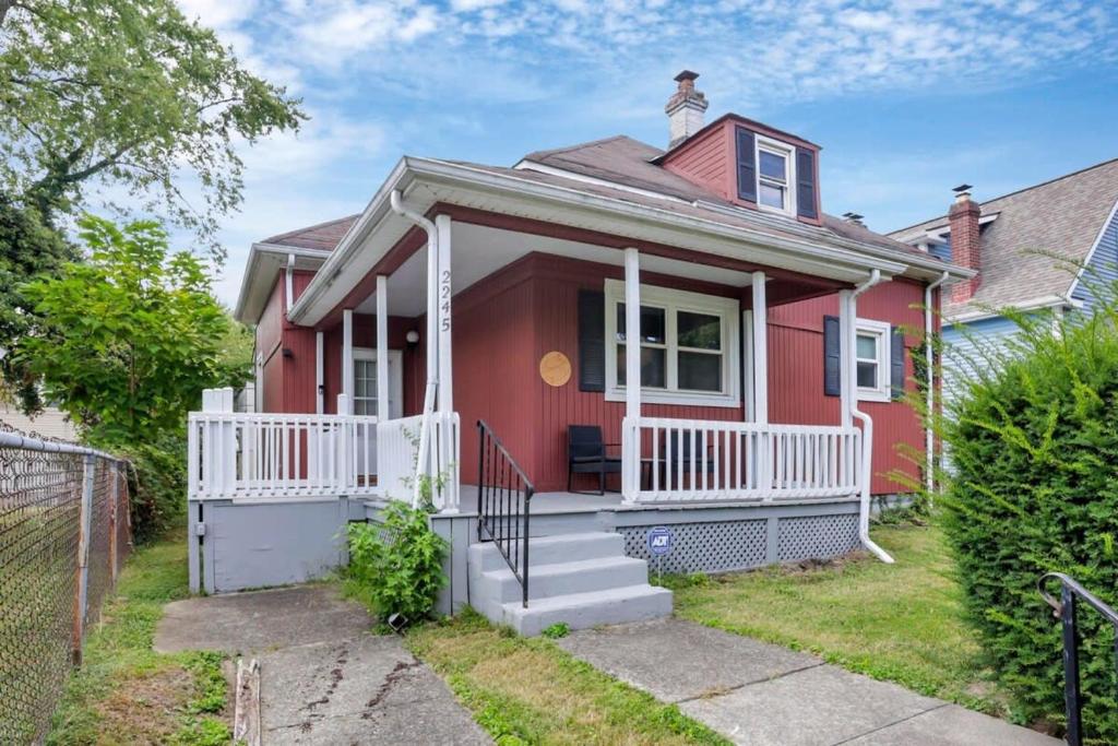 a red house with a white porch at The Scarlet Adventure in Columbus