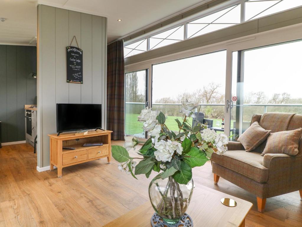 a living room with a couch and a vase of flowers at Cedar Lodge in Newark-on-Trent