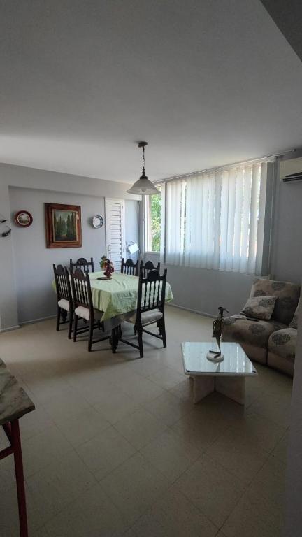 a living room with a table and chairs and a couch at Departamento en excelente área in Villa Marini