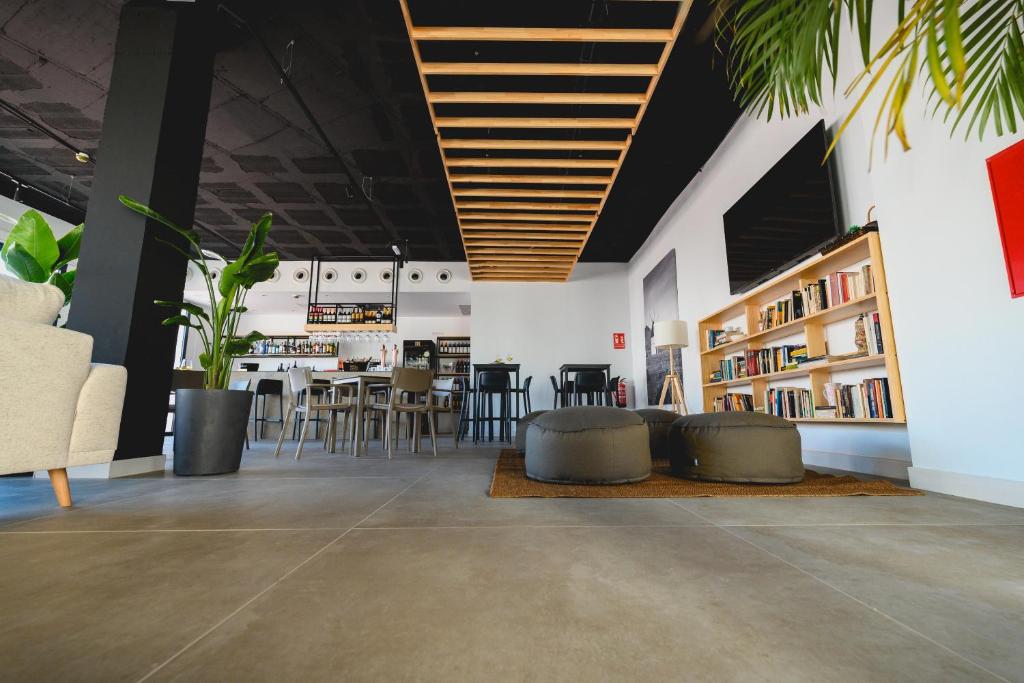 a living room with chairs and tables and bookshelves at HOTEL ALOVE in San José