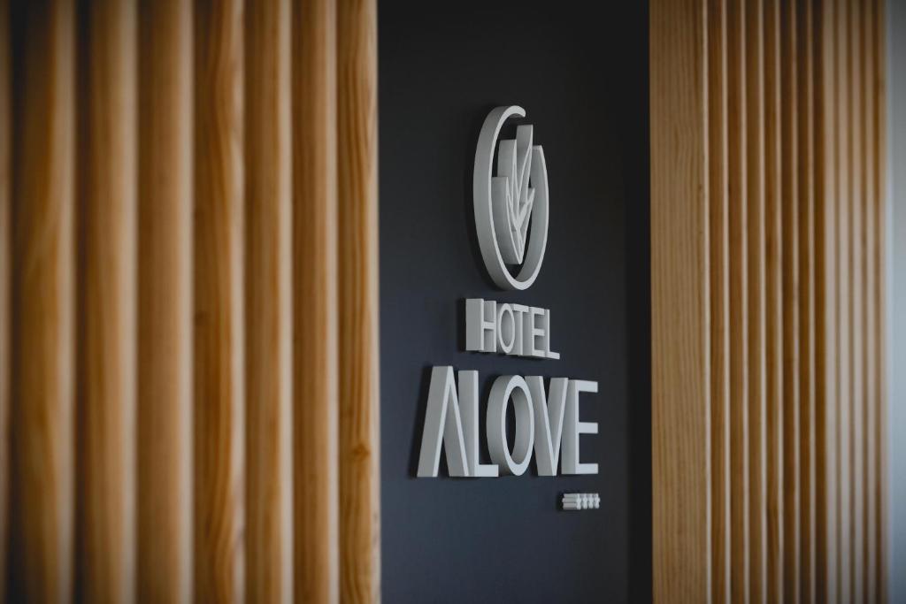 a sign that sayshero rave on a wall next to some curtains at HOTEL ALOVE in San José