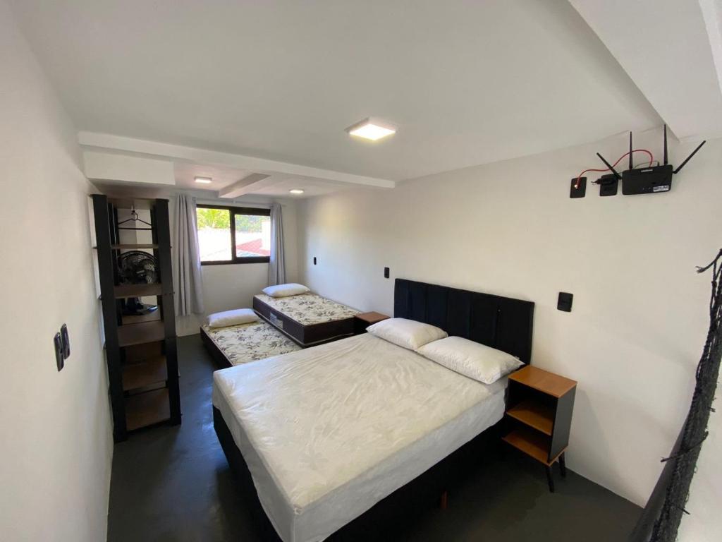 1 dormitorio con cama y sofá en Lofts Meia Morada SFS en São Francisco do Sul