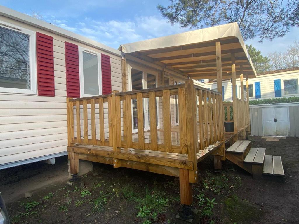 una casa con terrazza in legno accanto a una casa di mobil home 394 - Domaine de Kerlann a Pont-Aven
