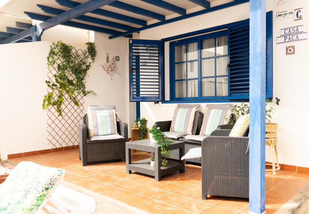 - un salon avec des canapés, des chaises et une fenêtre dans l'établissement Casa Paca - Your Private Oasis in Lanzarote - Paradise by the Sea, à Playa Blanca