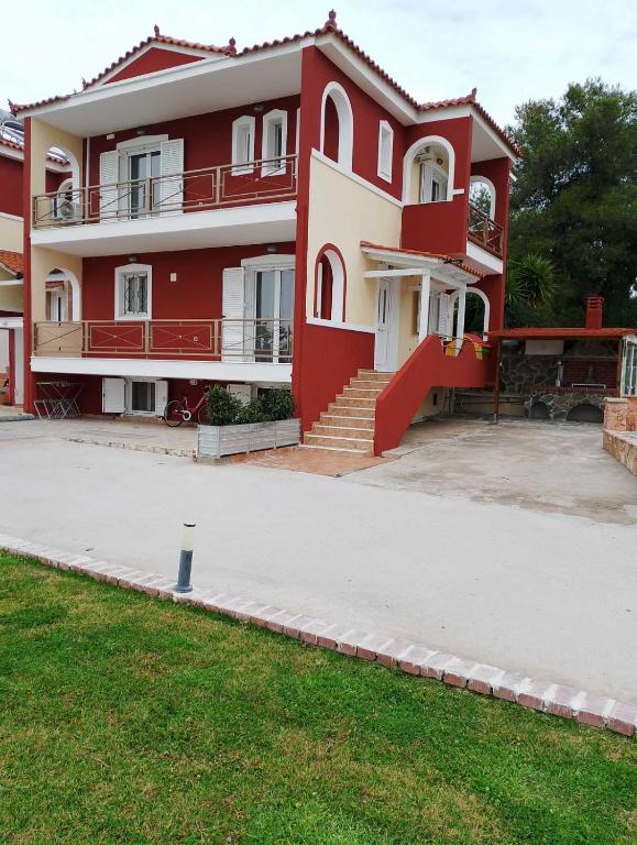 a red and white building with stairs and a yard at Villa Ioulia Malakonda, Eretria ,Greece in Eretria