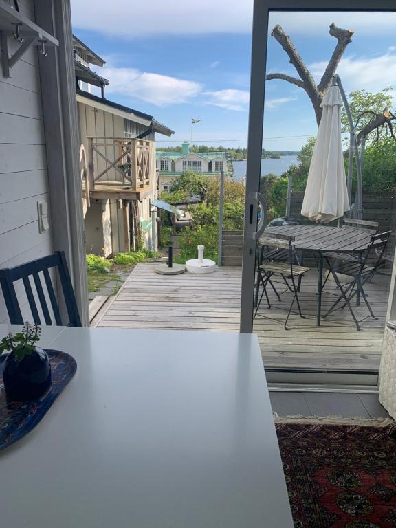 a patio with a table and an umbrella on a deck at Sommarvilan in Vaxholm