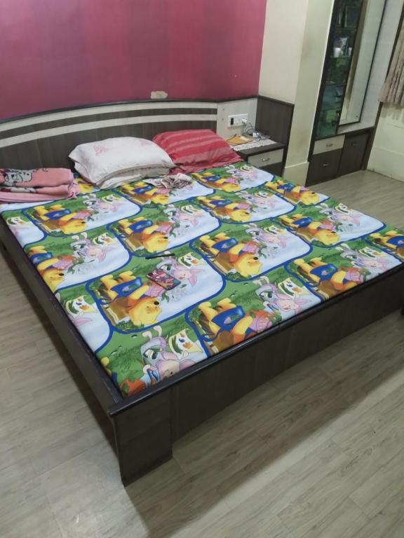 Una cama en una habitación con una manta. en MODI en Calcuta