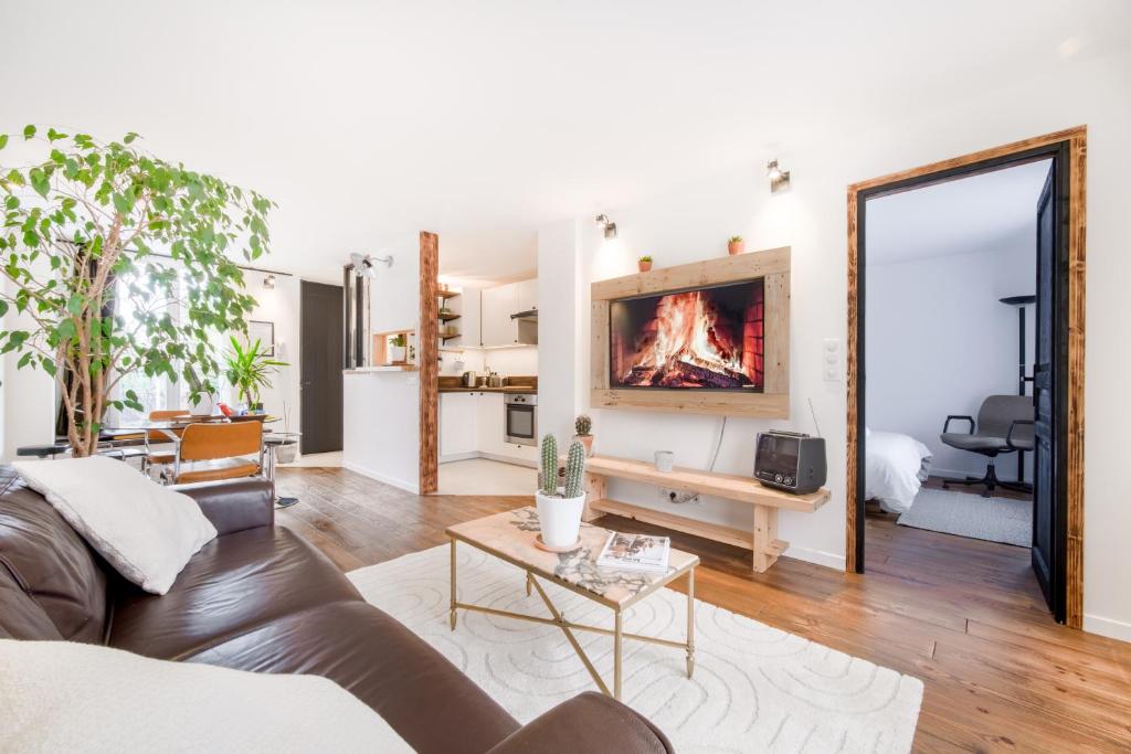 un salon avec un canapé et une cheminée dans l'établissement L'Éclat de Label Pierre, à Combs-la-Ville