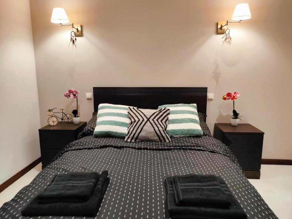 ein Schlafzimmer mit einem großen Bett mit zwei Nachttischen in der Unterkunft Apartament przy Operze in Białystok