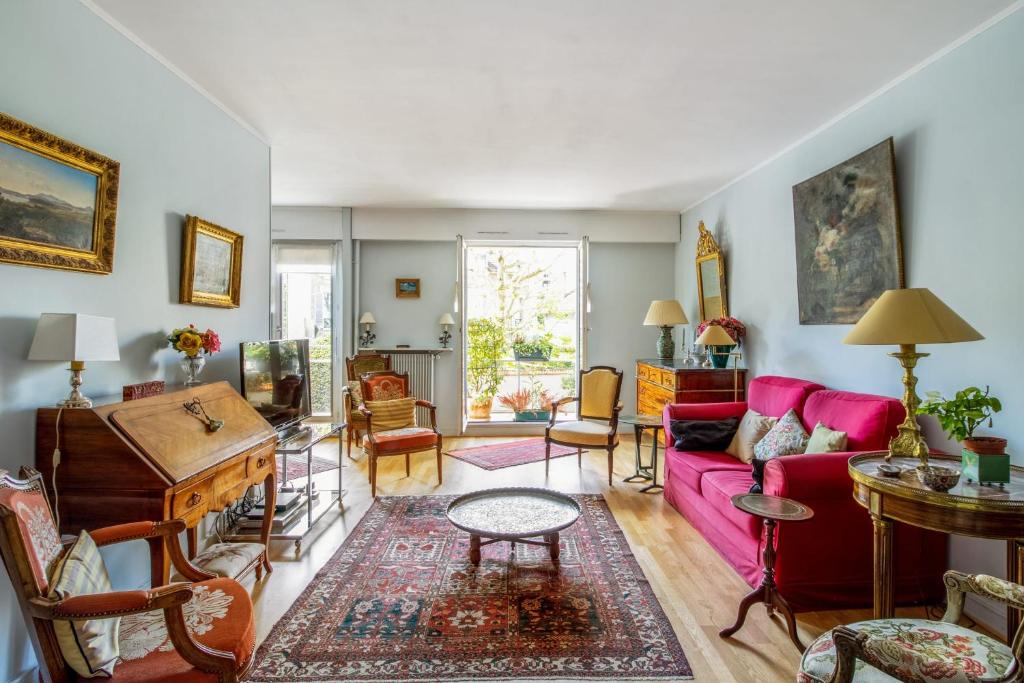 - un salon avec un canapé rose et un piano dans l'établissement Appartement Arazzo - Welkeys, à Versailles