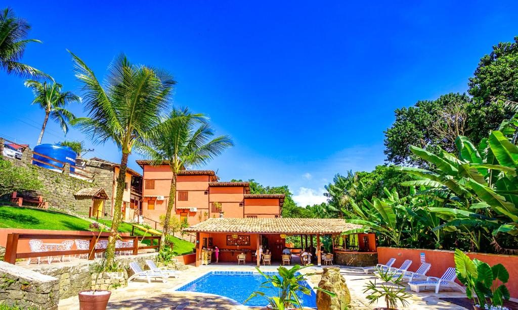 a villa with a swimming pool and a resort at VELINN Pousada Canoa Ilhabela in Ilhabela
