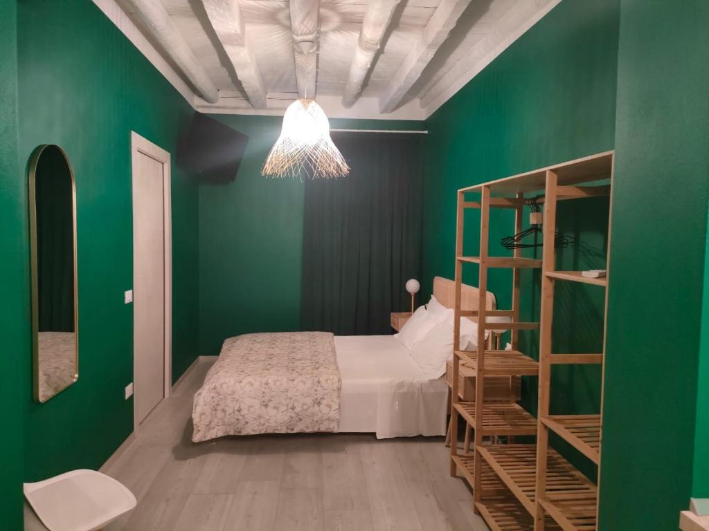 a green bedroom with a bed and a book shelf at Residenza Sant'Andrea Smeraldo in Chioggia