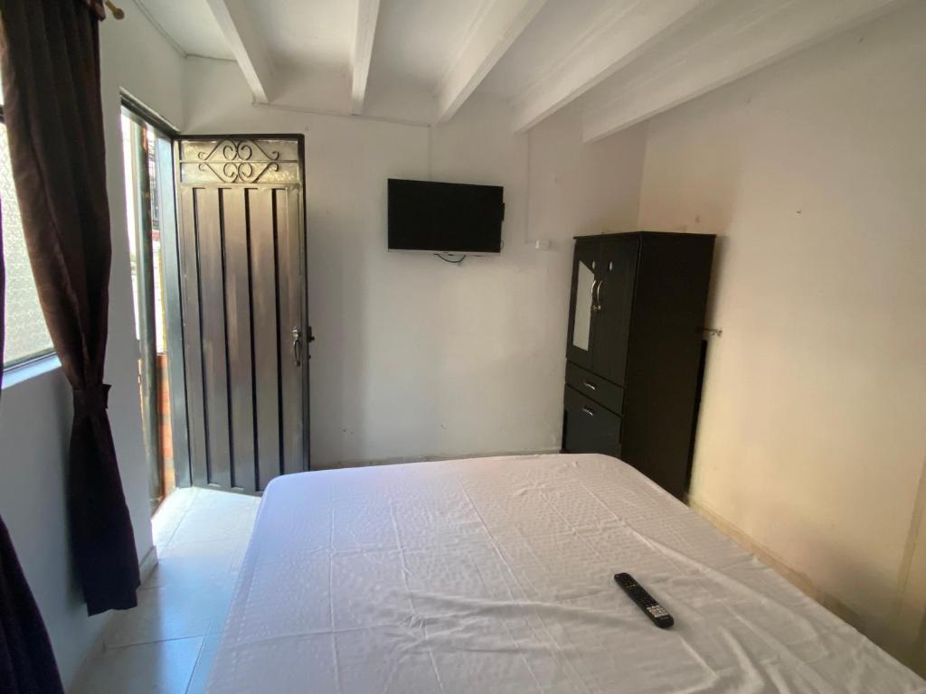 a bedroom with a bed and a television on the wall at Apartaestudio Bellapalma Socorro Calle 16a # 7-37 in Socorro