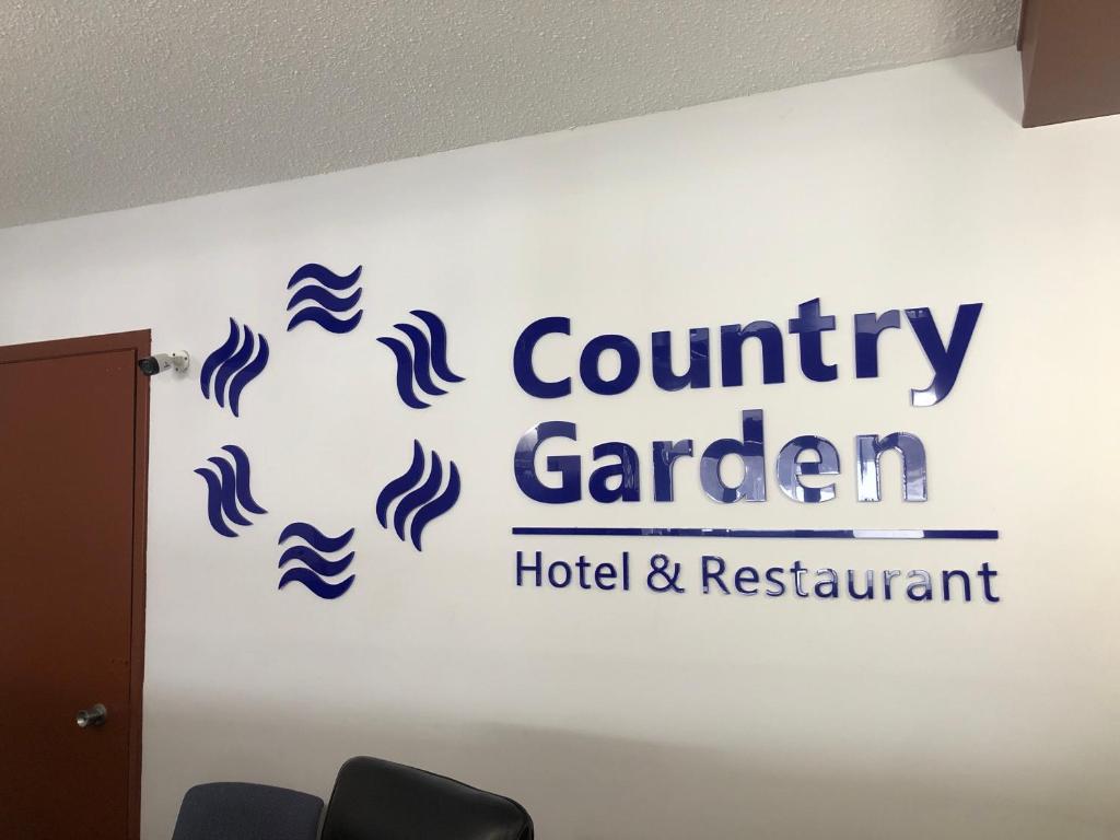 een bord voor een county garden hotel en restaurant aan een muur bij Country garden hotel in Smoky Lake