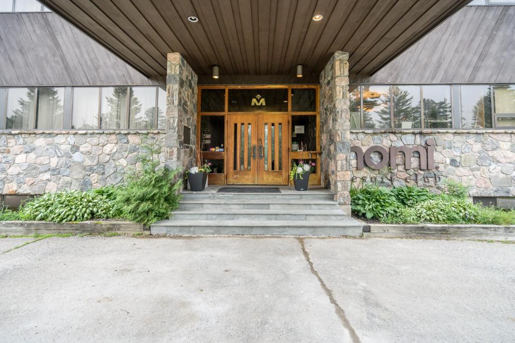 - Entrada a un edificio con puerta de madera en Nomi Resort en Harcourt
