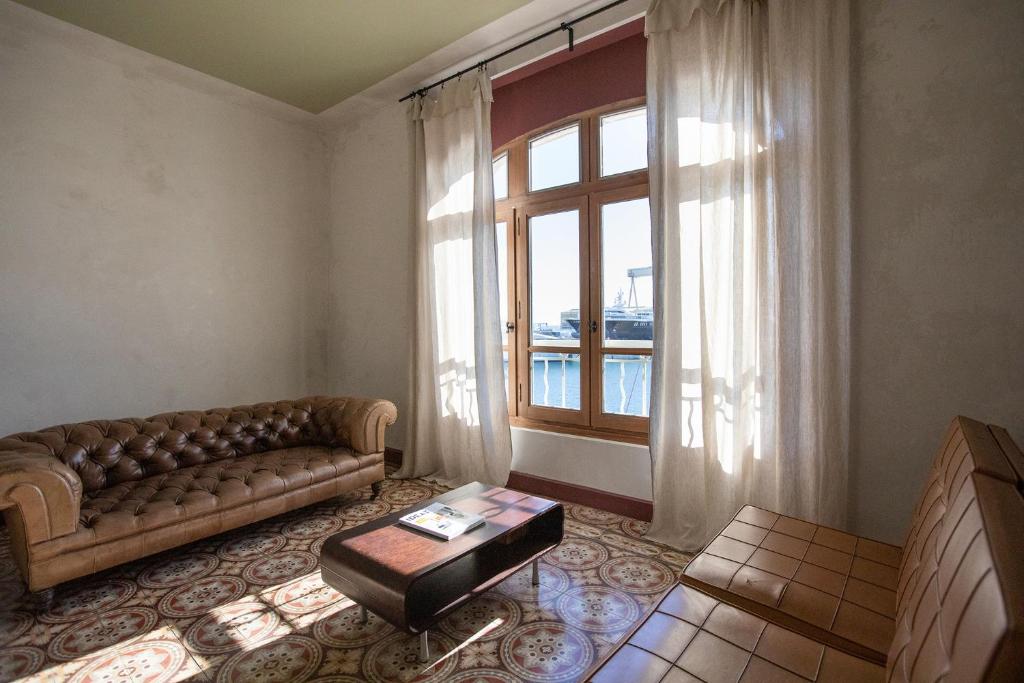 een woonkamer met een bank en een groot raam bij CASA ABEILLE in La Ciotat