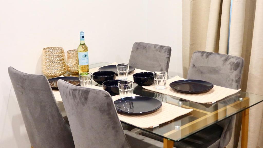 una mesa con sillas y una botella de vino en New Luxury Suite 6Mins To Falls, Free Parking, en Niagara Falls