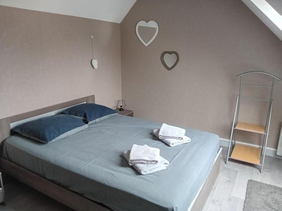 une chambre avec un lit bleu avec des serviettes dessus dans l'établissement Appartement Le Marceau, proche de la Mer., au Crotoy