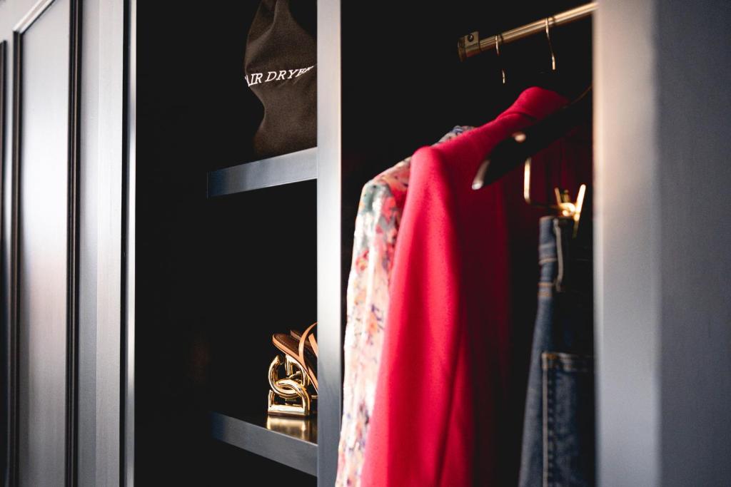 a closet with a red jacket on a rack at Beacon Grand, A Union Square Hotel in San Francisco