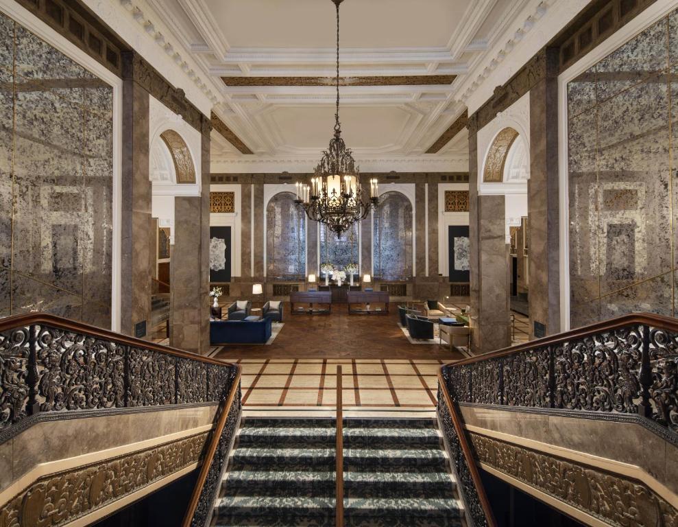 a lobby with a staircase and a chandelier at Beacon Grand, A Union Square Hotel in San Francisco