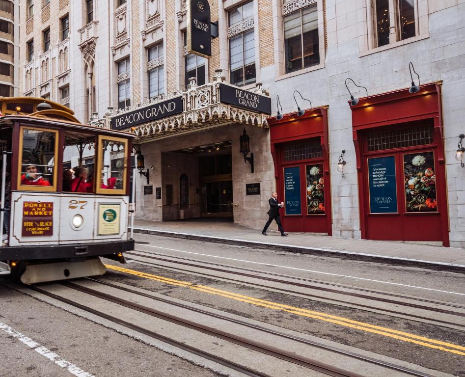 a trolley car on a street in front of a building at Beacon Grand, A Union Square Hotel in San Francisco