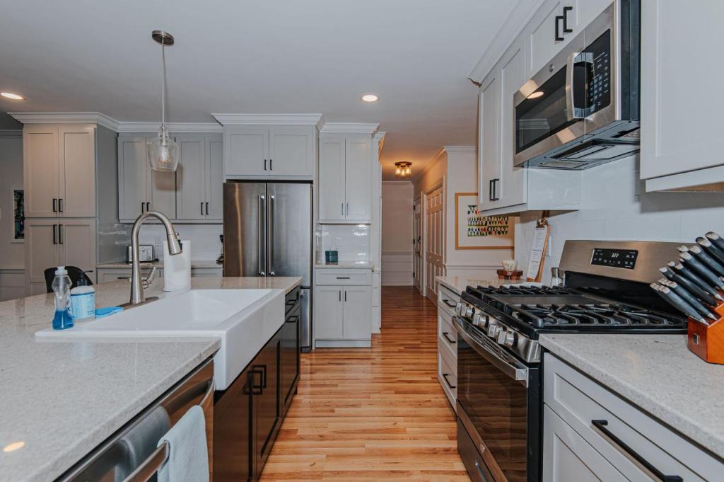 uma cozinha com electrodomésticos brancos e pisos em madeira em Artopia Retreat em Greensboro