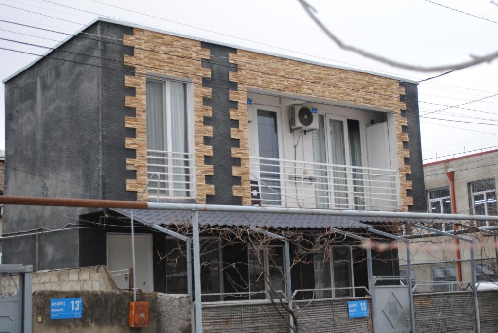 a brick house with a balcony on a street at Sweet home in Tbilisi City