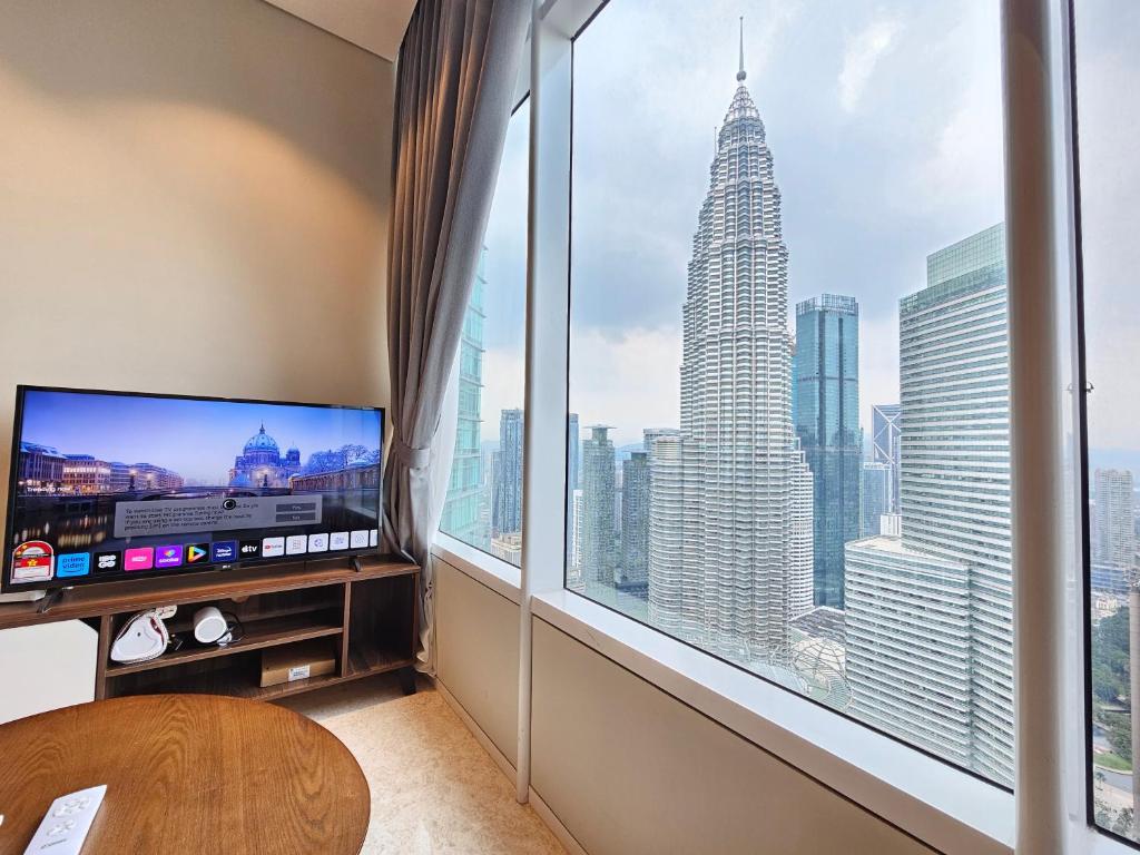 Sky Suites & Residence KLCC Kuala Lumpur في كوالالمبور: غرفة مع نافذة كبيرة مطلة على ناطحة السحاب
