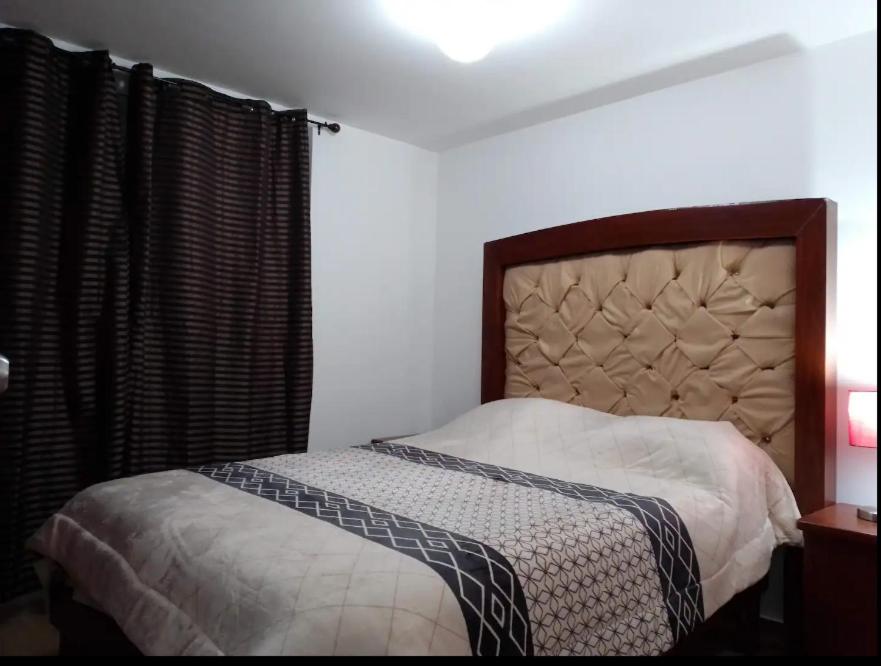 a bedroom with a bed with a headboard and a window at Qhapac Casa San blas 1 in Cusco