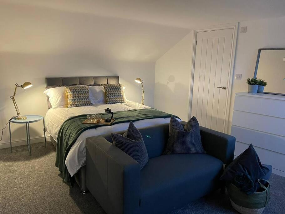 - une chambre avec un lit et un canapé bleu dans l'établissement Modern 6bedroomall ensuite in Birkenhead Free Parking and Wifi, à Wallasey