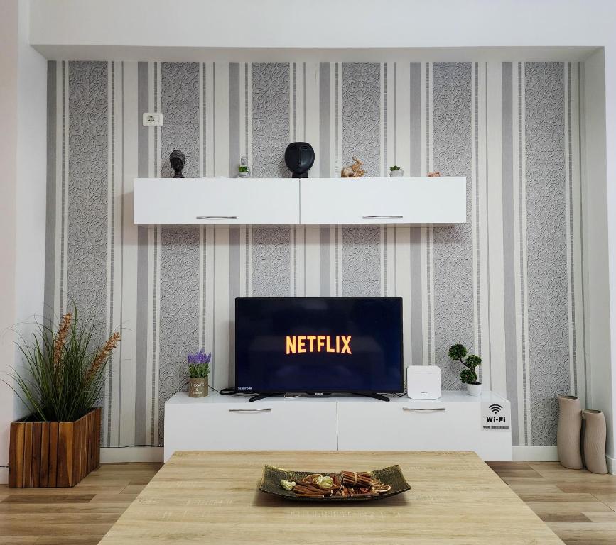 una sala de estar con TV en un armario blanco en 2E Apartment Myslym Shyri, en Tirana