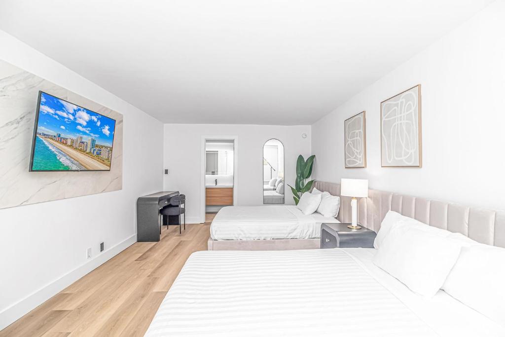 1 dormitorio blanco con 2 camas y sofá en Fifth and Ocean, en Myrtle Beach