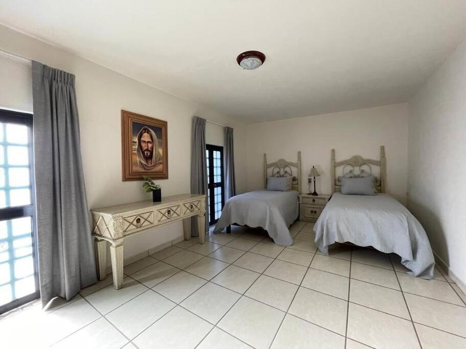 een slaapkamer met 2 bedden en een raam bij Casa los Mariachis centro in San Juan de los Lagos