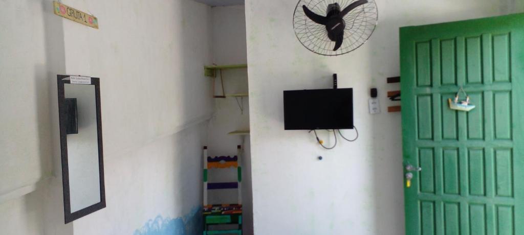 薩誇雷馬的住宿－Gruta da Praia 1，一间设有绿门和墙上电视的房间