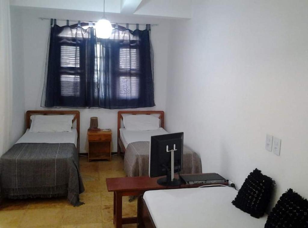 um quarto com 2 camas e uma secretária com um computador portátil em Jeri laguna chalés paraiso em Jijoca de Jericoacoara