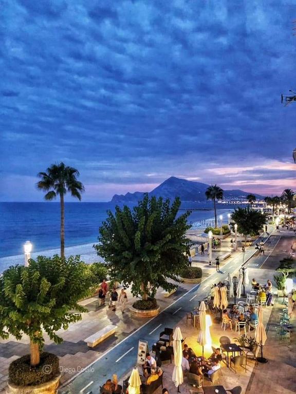 a group of people sitting at tables near the beach at Casa Francesca Altea piscina y aparcamiento privado in Altea