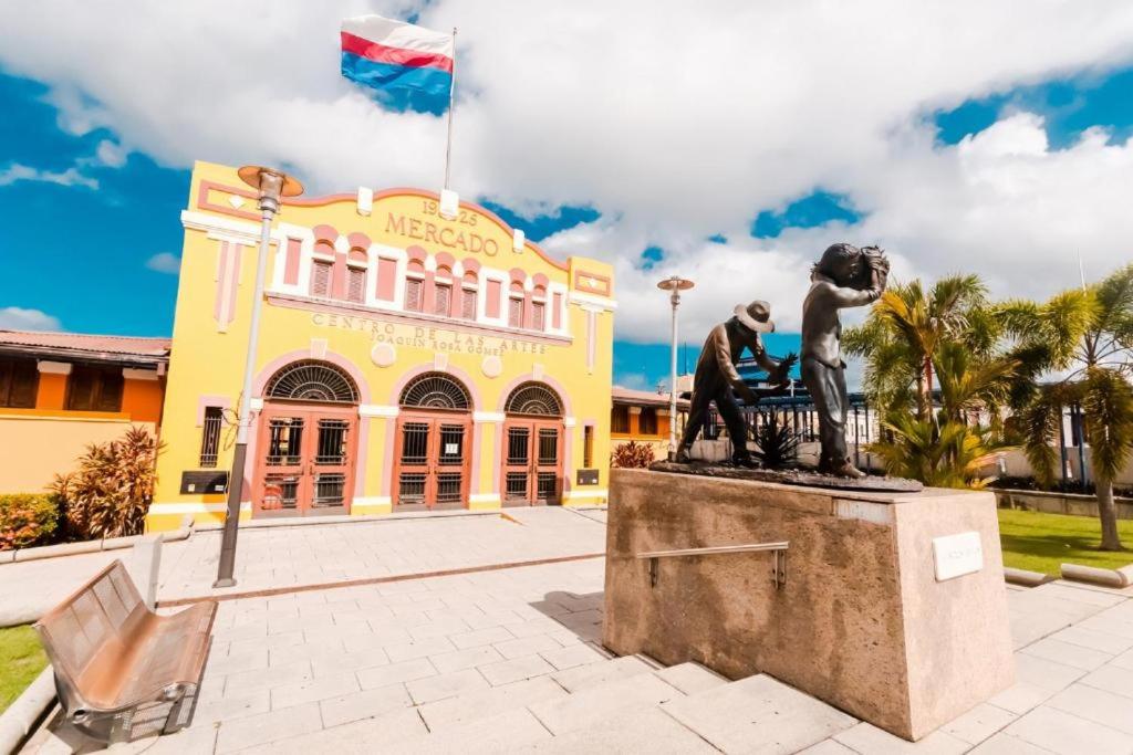 a statue of two people sitting on a bench in front of a building at Manati Amazing Studios in Manati