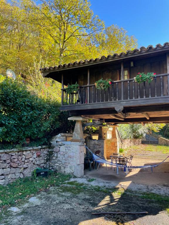 a house with a deck and a bench under a bridge at Casa rural en Redes in Ríoseco