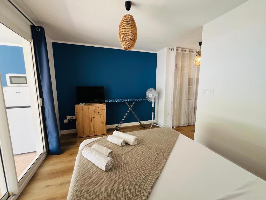 a bedroom with a bed and a blue wall at Piscine Paradise résidence Ocean garden in La Saline les Bains