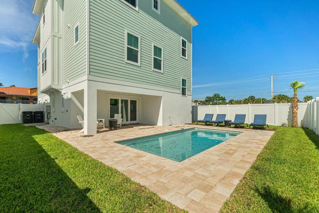 une maison avec une piscine dans la cour dans l'établissement Endless Summer Oasis Heated Pool And Putting Green, à Saint Augustine Beach