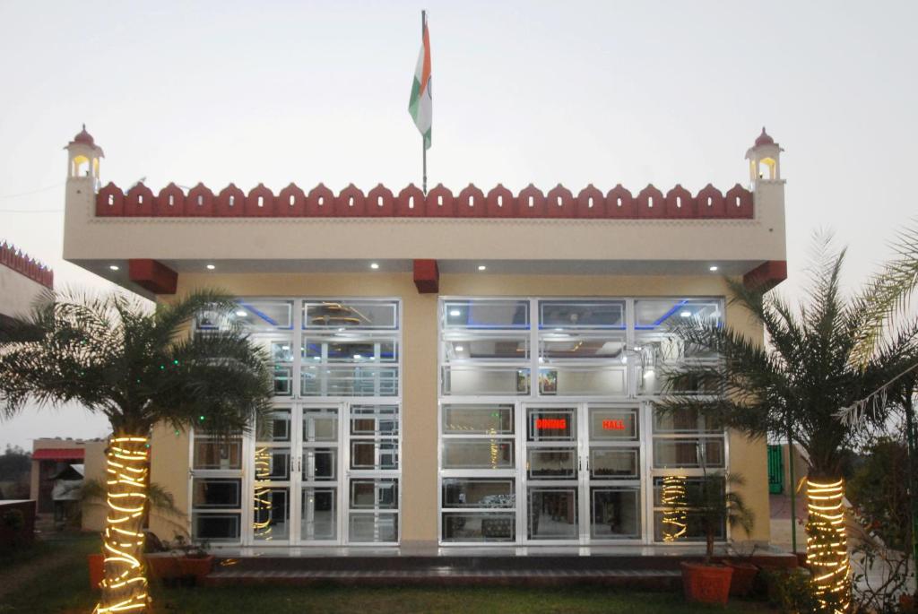 Un edificio con dos palmeras delante. en Yuvraj Nature Resort, en Pushkar