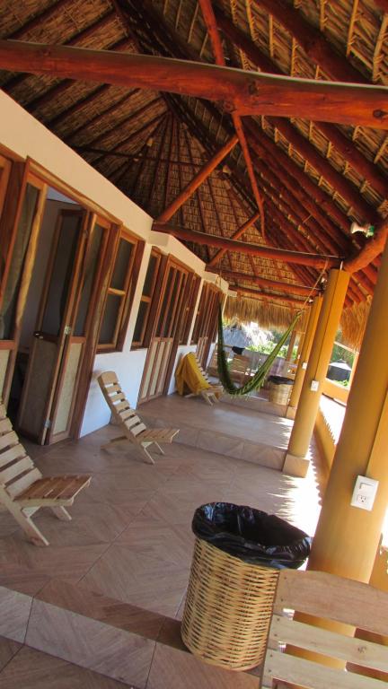 una habitación al aire libre con sillas y techo de paja en Hab #5 La Casa Del Profe Salo, en Santa María Tonameca