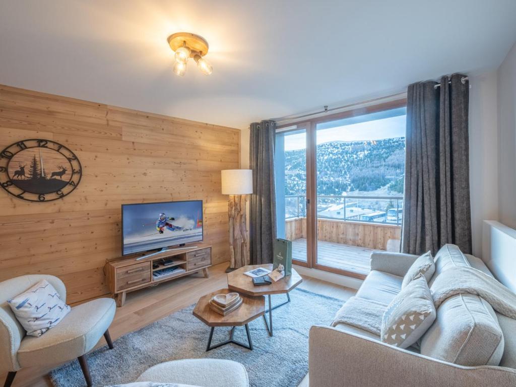 un salon avec un canapé et une télévision dans l'établissement Appartement neuf, spacieux, proche pistes et centre, parking et wifi inclus - FR-1-645-61, à Huez