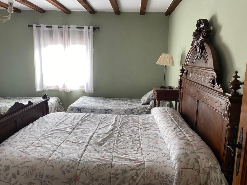a bedroom with two twin beds and a window at Doña Elvira y Doña Sol in Vivar del Cid