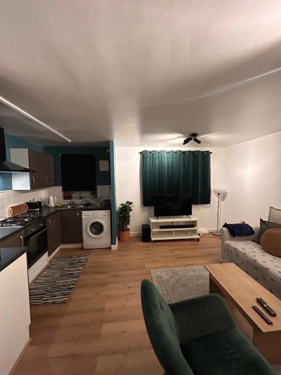a living room with a couch and a kitchen at Woodhouse Apartment in Headingley