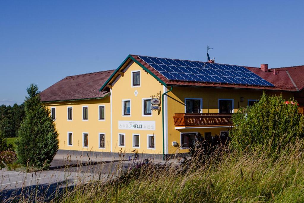 una casa amarilla con paneles solares. en Gasthof Einfalt en Grossgerungs