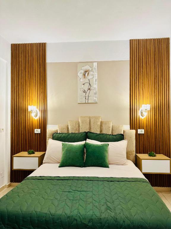 ein Schlafzimmer mit einem großen Bett mit grünen und weißen Kissen in der Unterkunft Feti Xhone Apartment in Ksamil